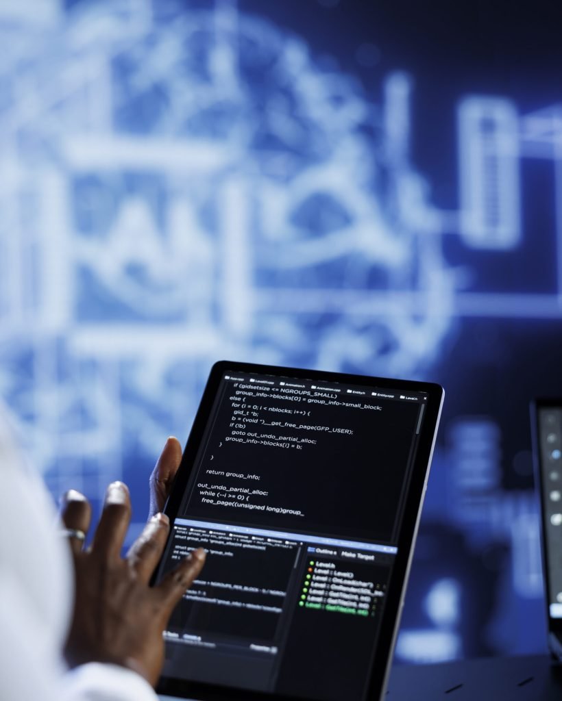 Trained developer updates neural networks made up of interconnected nodes, writing intricate binary code scripts on tablet. Expert uses programming to upgrade AI simulation model, blurry background